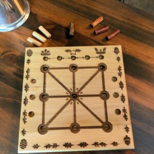 A wooden nature themed Three Men's Morris Board featuring acorns and pinecone motifs